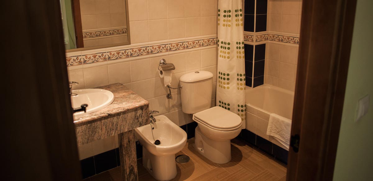 Un aseo completo de un apartamento del Complejo Rural Puerto Mágina. Inodoro, bidé, lavabo y bañera.