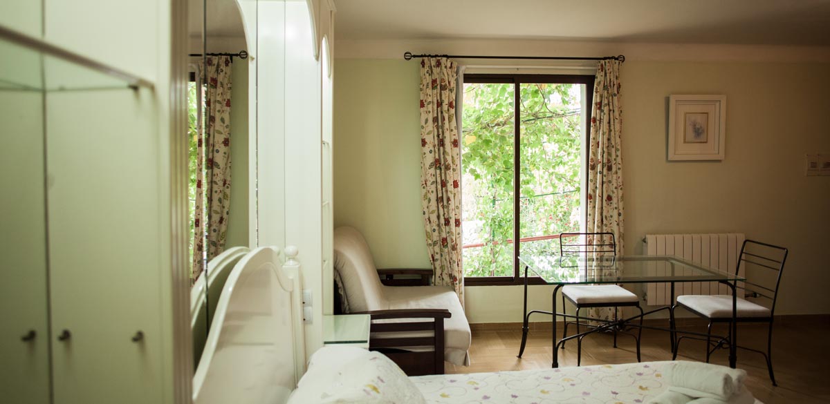 Una de las habitaciones del Complejo Rural Puerto Mágina donde se destaca, en la fotografía, el gran ventanal con vistas a Sierra Mágina.